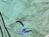 a green jacket with a blue bird on it