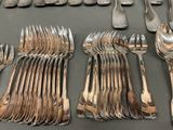 many forks and spoons laid out on a table
