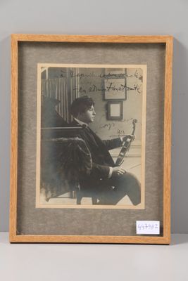 an old photo of a man sitting in a chair with a book