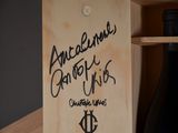 a wooden box with a bottle of wine in it