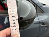 a person holding a ruler in front of a car