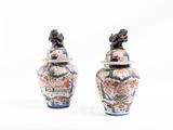 deux vases posés l'un à côté de l'autre sur une surface blanche