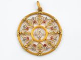 un gros plan d'un pendentif en or et diamants sur fond blanc
