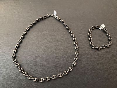 a black and white photo of a necklace and bracelet on a table