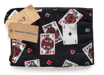 a black purse with playing cards and a tag on it