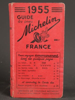 a red book sitting on top of a table next to a black table