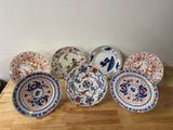 six assiettes ornées de motifs différents, posées sur une table en bois