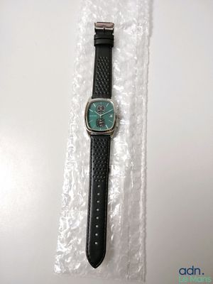 a close up of a watch on a plastic bag on a table