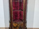 a glass display cabinet with a red velvet covering
