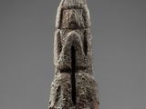 a stone statue of a man holding a sword on a stand