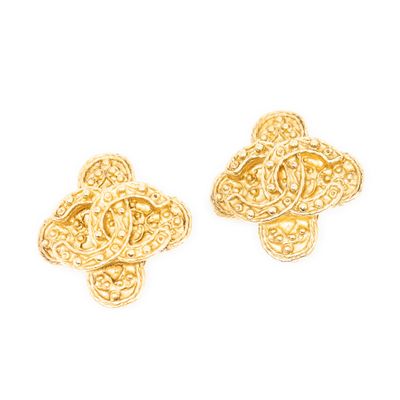 une paire de boucles d'oreilles dorées au motif raffiné