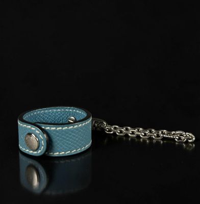 blue leather wrist cuff with chain on a black background
