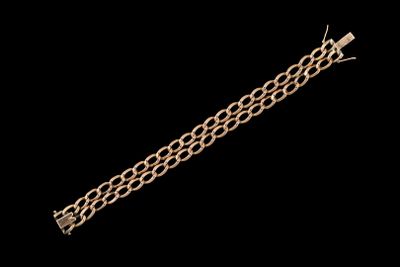 gros plan d'un bracelet en chaîne en or sur fond noir