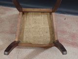 a wooden chair with a wicker seat on the floor