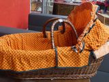 a wicker basket with a blanket in it on a table