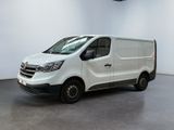 La camionnette blanche est garée dans une grande pièce aux murs blancs.
