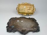 two pieces of gold and silver are sitting on a white surface