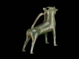 bronze statue of a giraffe standing on its hind legs on a black background