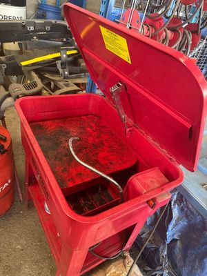 une boîte à outils rouge, ouverte, posée dans un garage