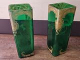 two green vases sitting on the floor next to each other