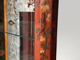 a glass display case with a red and gold design on it
