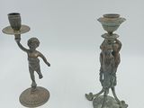 deux bougeoirs en bronze posés sur une table