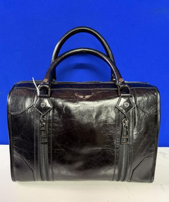 un sac en cuir noir posé sur une table blanche