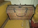 an old suitcase sitting on the floor next to a chair