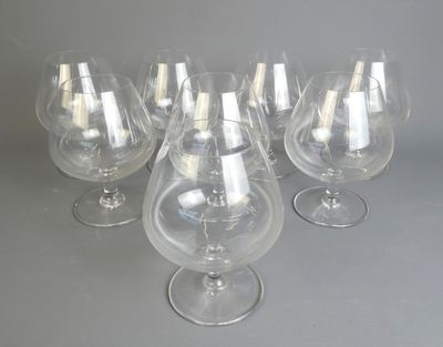 six verres à vin vides sont alignés sur une surface grise