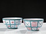pair of blue and white bowls with flowers on them sitting on a table