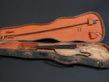 un étui à violon contenant un violon, posé sur une surface noire