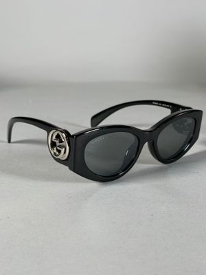des lunettes de soleil noires avec le logo Gucci sur les branches