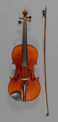a violin with a bow and a bow rest on the wall