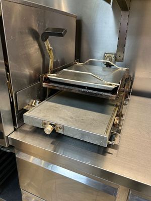 un grand four en métal surmonté d'une plaque