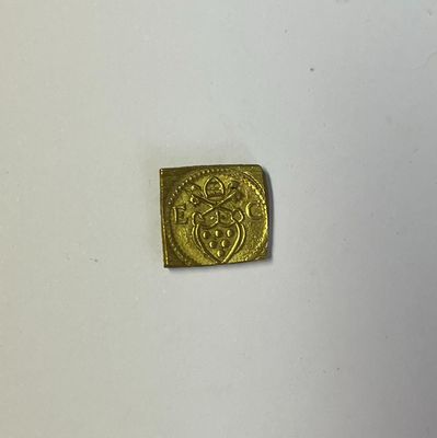 gros plan d'une pièce d'or sur une surface blanche