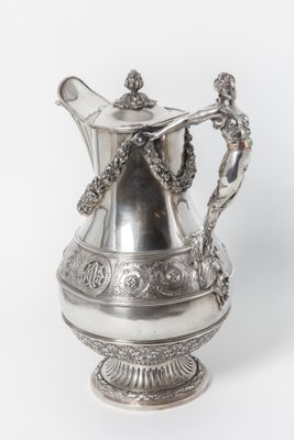 a silver coffee pot with a handle on a white background
