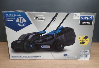 le carton d'une tondeuse à gazon filaire est posé sur une table