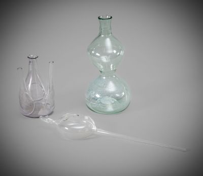 two glass vases and a bottle on the table