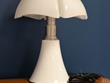 une lampe posée sur une étagère près d'un mur bleu