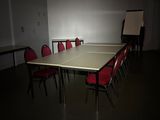des tables et des chaises dans une pièce où est accroché un tableau blanc au mur
