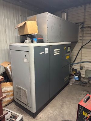 an image of a refrigerator in a garage with a lot of junk