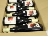 six bottles of wine in a cardboard box on a table