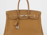 un sac à main en cuir marron muni d'un cadenas sur la poignée