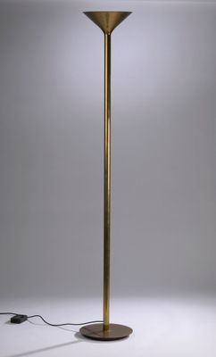 a brass floor lamp with a white shade on top of it