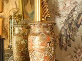 une photo d'une cheminée sur laquelle sont posés une horloge et des vases