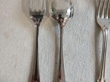 trois fourchettes et deux cuillères posées sur une table