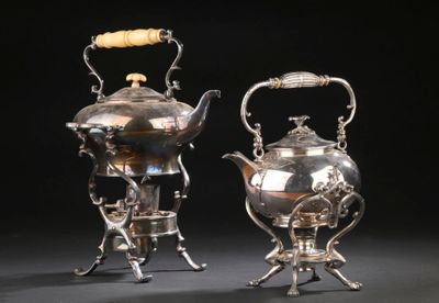 paire de théières anciennes en argent sur un support, sur fond noir