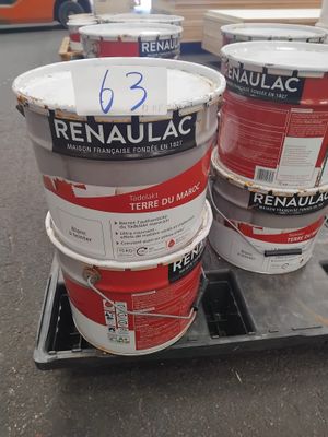 trois seaux de peinture posés sur une palette dans un entrepôt