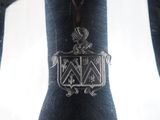 a close up of a silver vase with a coat of arms on it