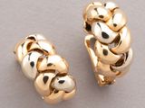 two pairs of gold plated hoop earrings on a white surface